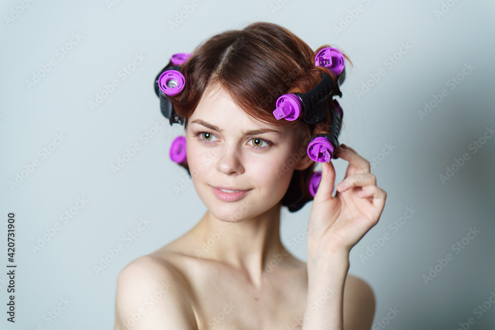 Naklejka premium happy woman with curly hair purple curlers hairstyle bare shoulders