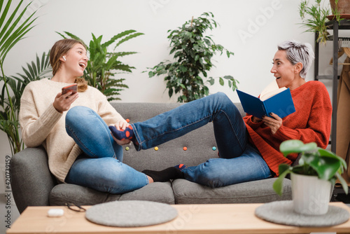 Laughing women fighting playfully on sofa photo