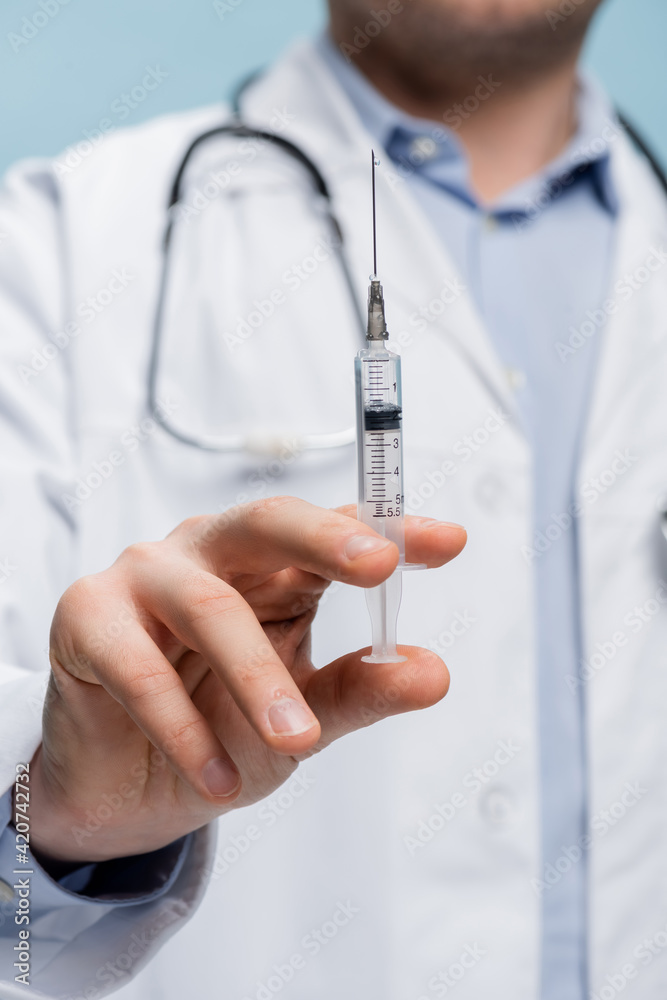 partial view of doctor holding syringe isolated on blue partial view of doctor holding syringe isolated on blue
