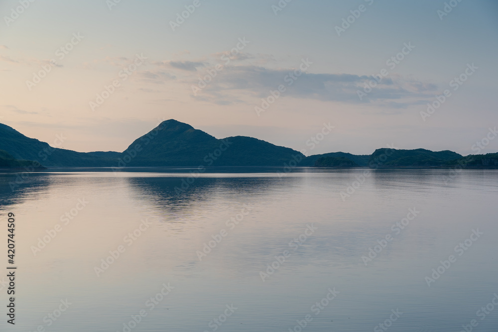 View of the coast and mountains of Geographic Harbor, Katmai, Alaska just after sunrise.