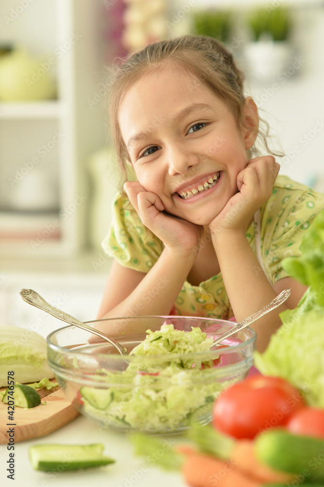 Cute girl preparing delicious fresh salad in kitchen Cute girl preparing delicious fresh salad in kitchen