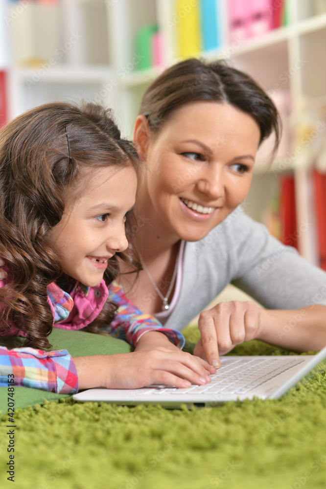 portrait of happy mother and daughter using laptop portrait of happy mother and daughter using laptop