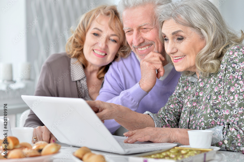 senior people with laptop drinking tea senior people with laptop drinking tea
