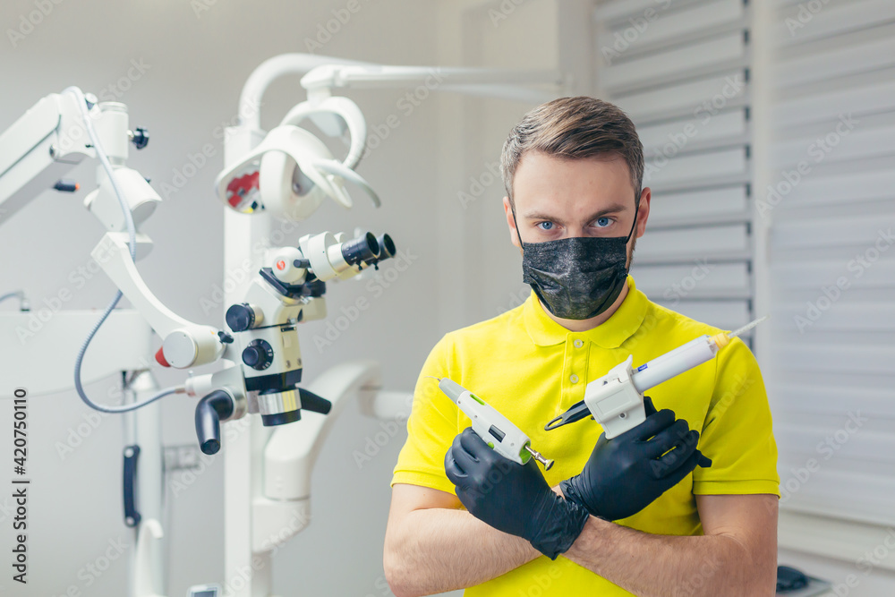Close up portrait of a confident dentist in a medical office or clinic. Attractive bearded young man, modern male doctor or friendly medic in the workplace. looking at the camera in hospital. closeup Close up portrait of a confident dentist in a medical office or clinic. Attractive bearded young man, modern male doctor or friendly medic in the workplace. looking at the camera in hospital. closeup