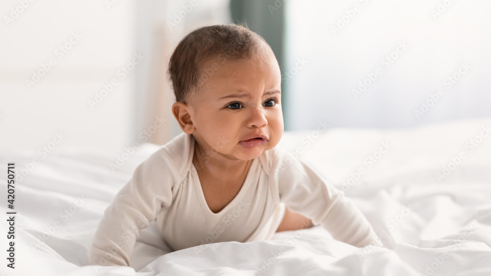 Portrait of sad black baby crying alone in bedroom Portrait of sad black baby crying alone in bedroom
