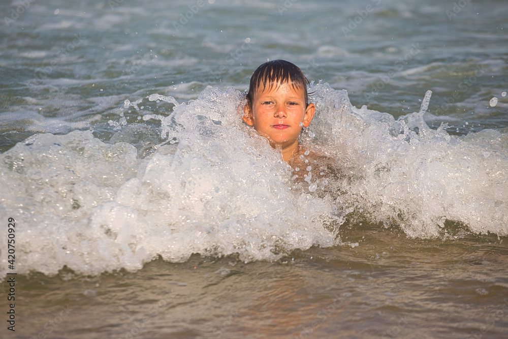 child swims in the sea waves on the beach child swims in the sea waves on the beach