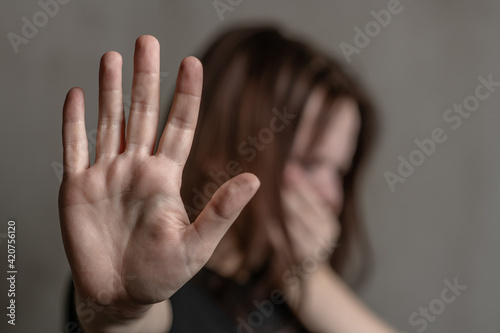 Crying teenage girl showing a stop sign with her hand