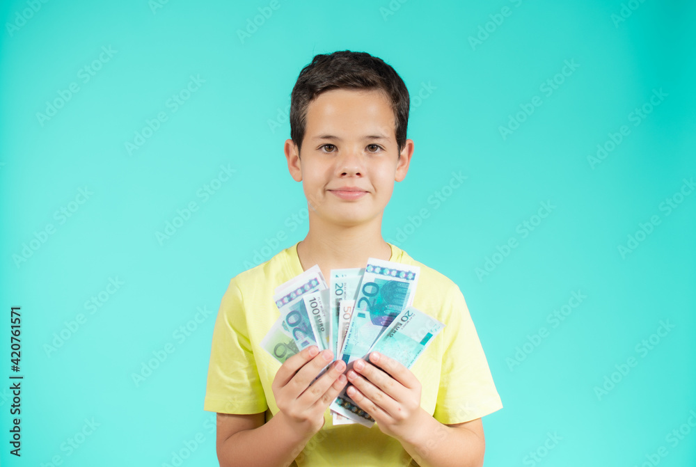 Surprised little boy with money cash. Cute kid hiding face behind fan of money bills. Lottery winner, businessman, success. Money saving. Money for future education.