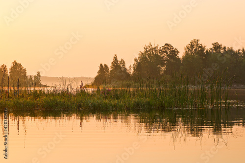 Early morning, calm water surface, fog over the lake. Summer landscape. Argazinskoe reservoir, Chelyabinsk, Russia