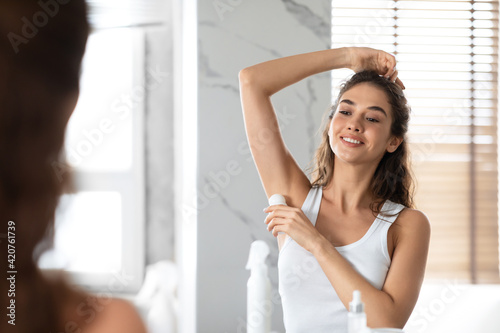 Lady Applying Antiperspirant Roll Underarms For Armpits Freshness In Bathroom photo