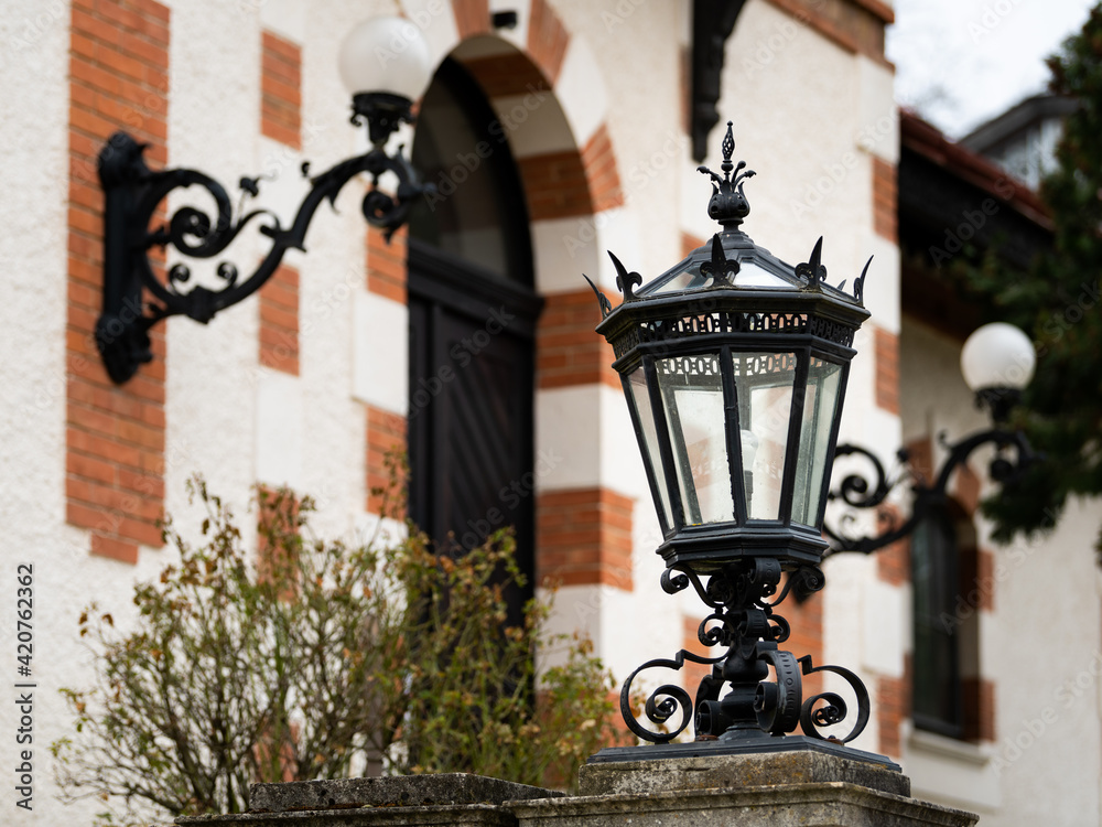Big old black lantern in front of an old house