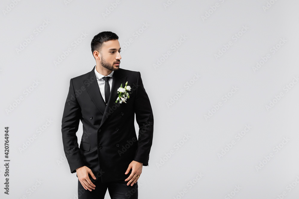 Muslim groom in suit and boutonniere looking away isolated on grey Muslim groom in suit and boutonniere looking away isolated on grey