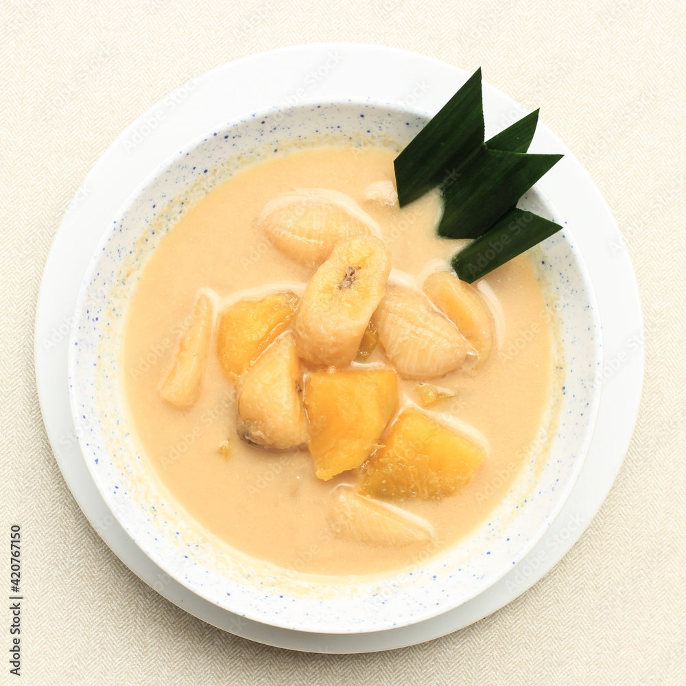 Top View Kolak Pisang Ubi or Banana and Sweet Potato Compote is Popular Indonesian Dessert made from Banana Sweet Potato Cooked with Coconut Milk, Palm Sugar, and Pandan Leaves. Popular during Ramadan