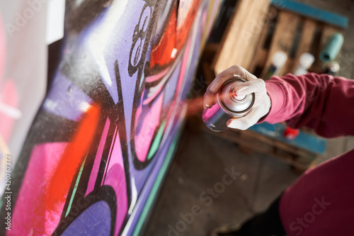 Street artist painting colorful graffiti