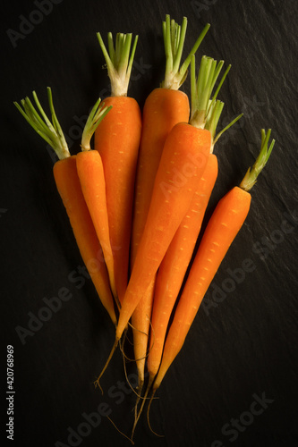 Obraz na płótnie Fresh organic carrots peeled for a healthy diet, on a black background w salonie