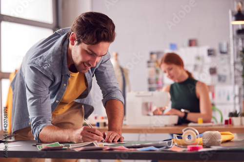 Male And Female Students Or Business Owners Working In Fashion Studio Together