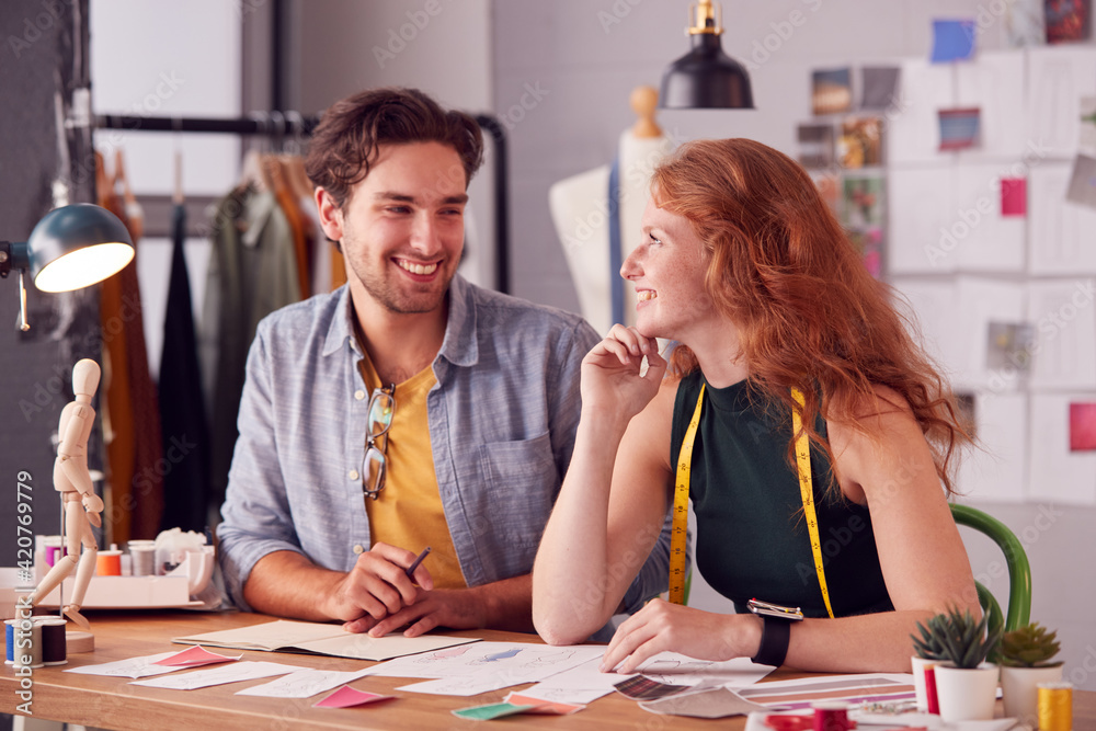Fototapeta premium Male And Female Students Or Business Owners Working On Designs In Fashion Studio Together