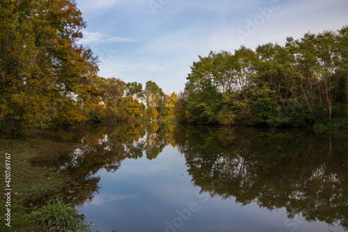 Landscape by the water. Stara Dyje river near Genoa castle in Czech republic. Trees are reflected in the river. Calm water. Colorful autumn. Beautiful clouds in the sky. photo