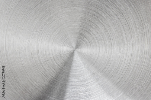 Metallic background of brushed chrome stainless steel surface with circular shapes.