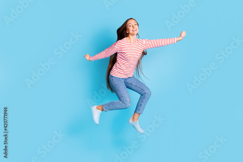 Full length body photo girl jumping cheerful happy wearing casual clothes isolated vivid blue color background