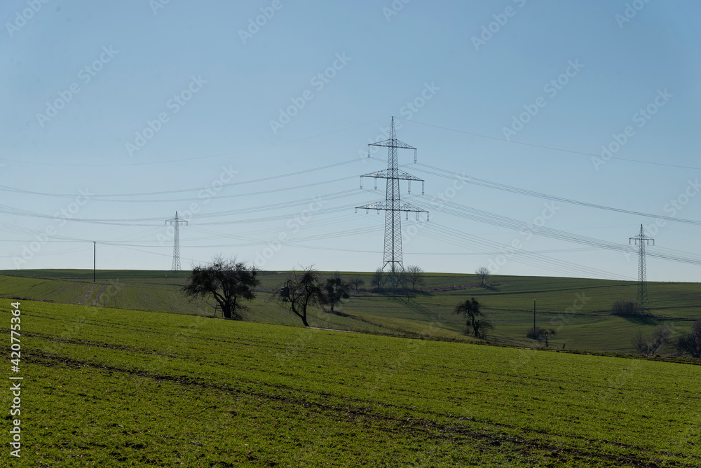 Strommasten auf grünem Feld

