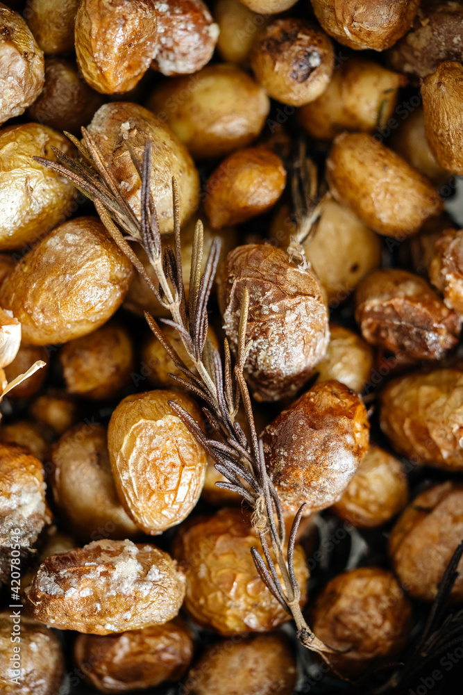 Golden fried or baked potatoes with a sprig of thyme in a frying pan, Macro photo with shallow depth of field. Golden fried or baked potatoes with a sprig of thyme in a frying pan, Macro photo with shallow depth of field.