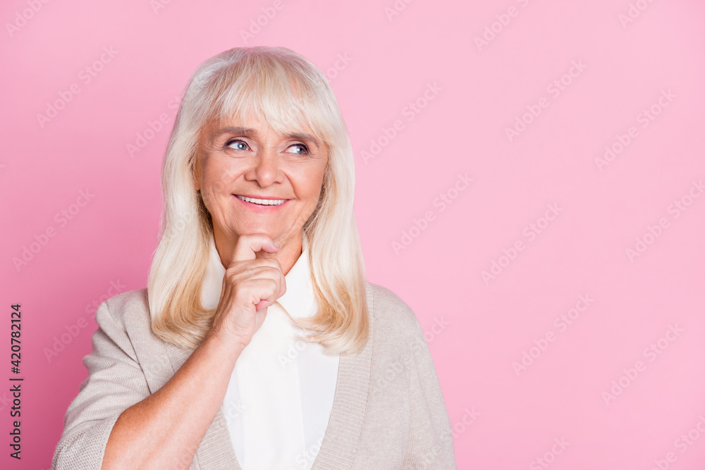Photo portrait of woman thinking looking at blank space touching face chin with finger isolated on pastel pink colored background Photo portrait of woman thinking looking at blank space touching face chin with finger isolated on pastel pink colored background