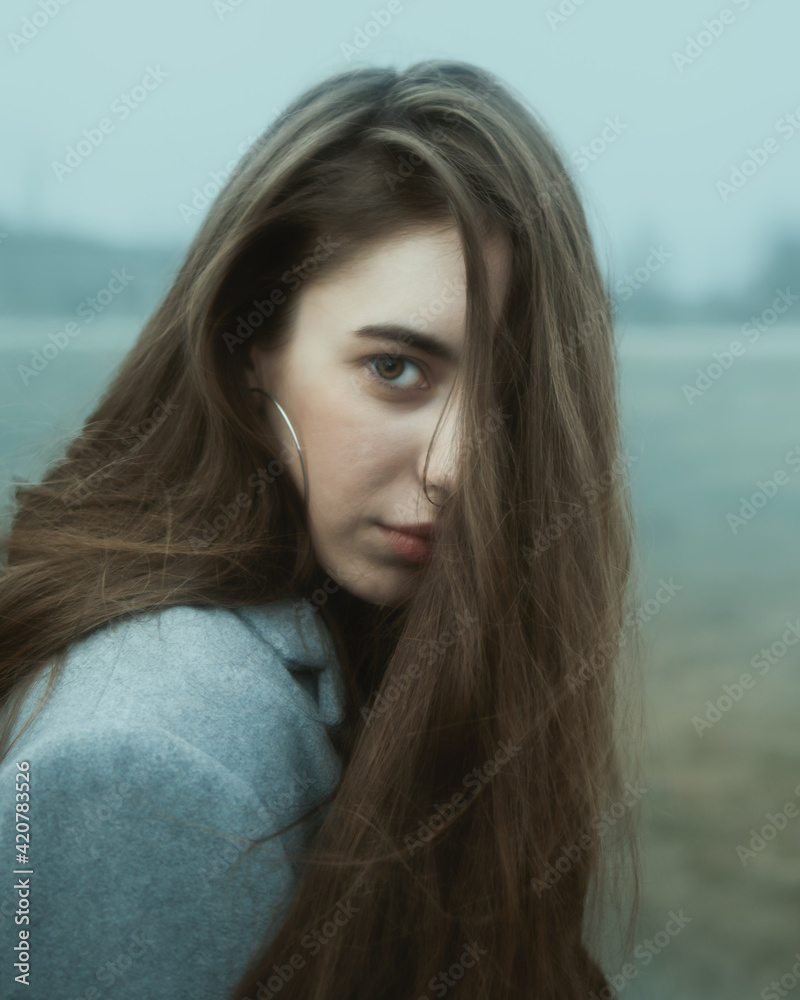 A girl walking in a foggy park