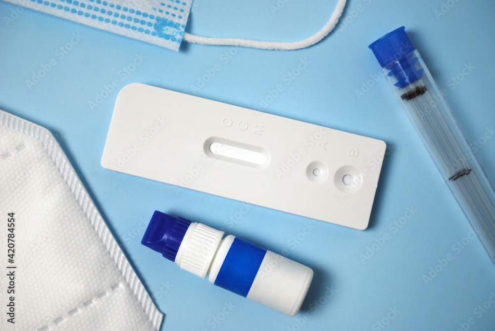 Top view photo of a rapid test for antibodies to coronavirus-19 with medical face mask,reagent and test tubes. Medical flatlay Top view photo of a rapid test for antibodies to coronavirus-19 with medical face mask,reagent and test tubes. Medical flatlay