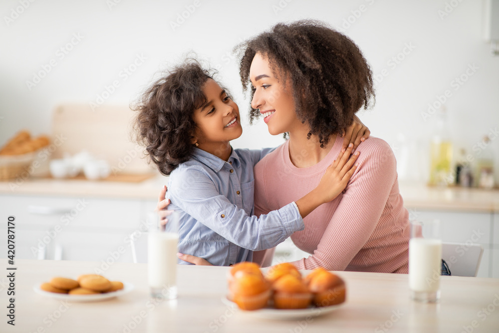 Cute Little Afro Girl And Woman Hugging In Kitchen