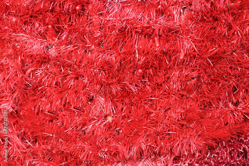 red tinsel texture with garlands and lights - closeup uniform surface for a background