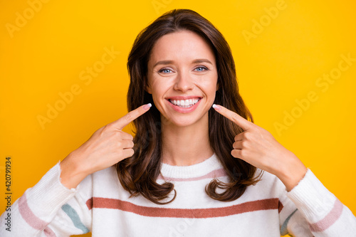 Photo of charming cheerful person indicate fingers toothy smile wear sweater isolated on yellow color background