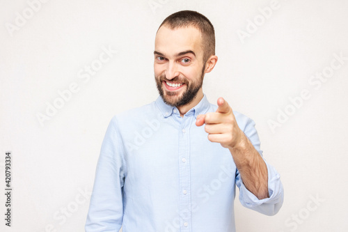 Cheerful bearded pointing finger at you camera gesture, white background