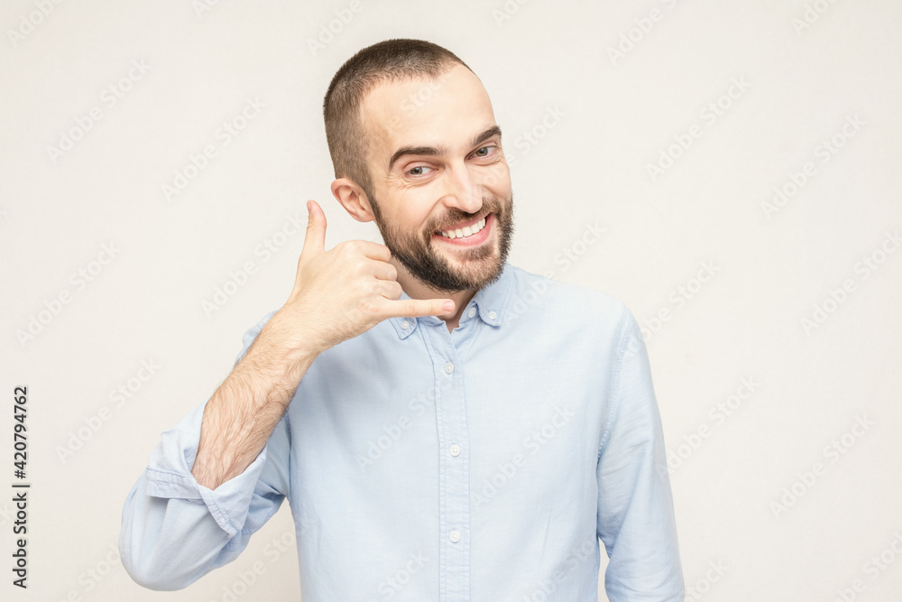 Joyful bearded shows the hand gesture call me, portrait, white background, copy space Joyful bearded shows the hand gesture call me, portrait, white background, copy space
