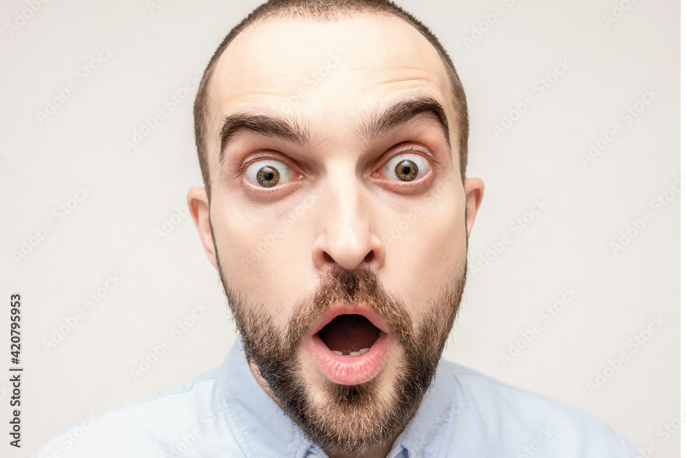 Puzzled confused bearded, portrait of shocked young man, white background, closeup Puzzled confused bearded, portrait of shocked young man, white background, closeup