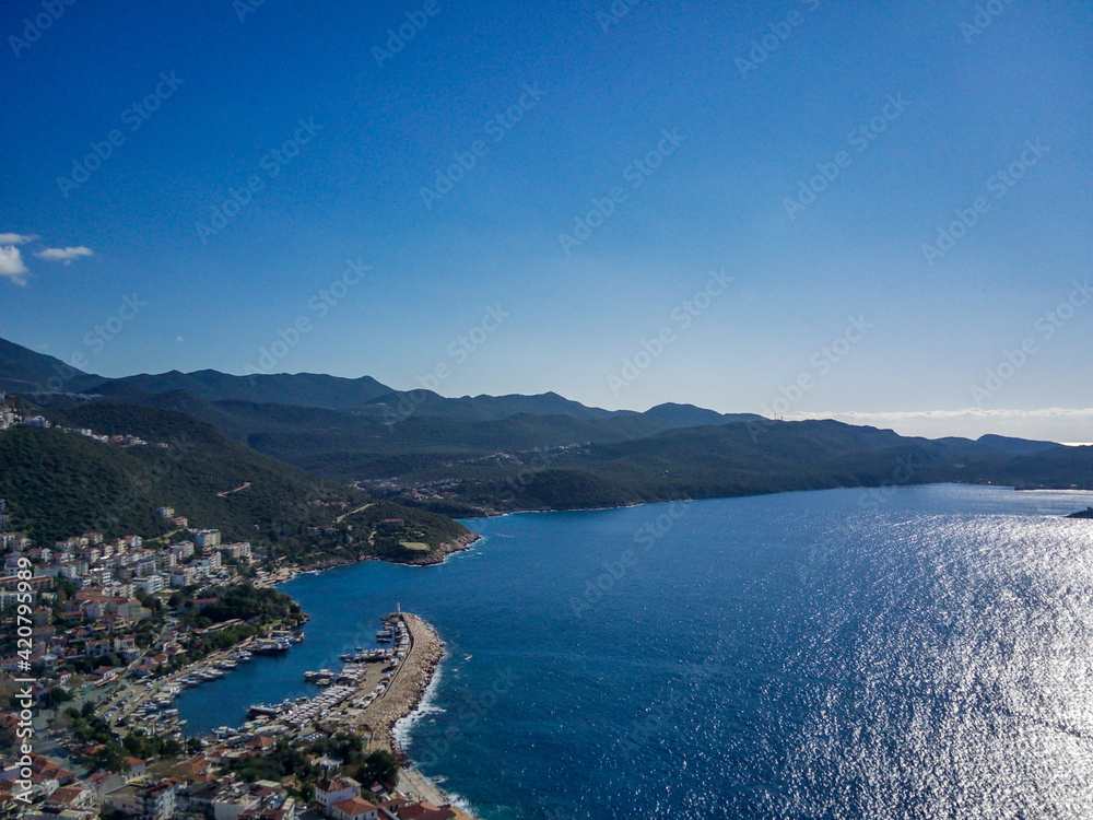 The top view from the drone of Kas resorts and city with amazing blue and clear lagoon and yachts in Mugla province of Turkey