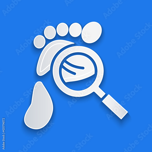 Paper cut Magnifying glass with footsteps icon isolated on blue background. Detective is investigating. To follow in the footsteps. Paper art style. Vector