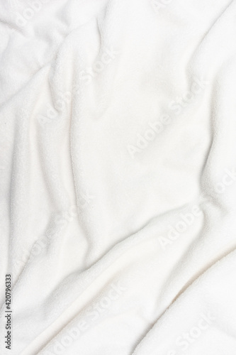 Imitation of a snow-covered surface, white crumpled plaid, background with copy space, top view, vertical