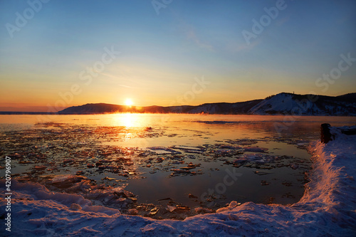 Beautiful sunset on Lake Baikal. Melting ice and open water in the lake