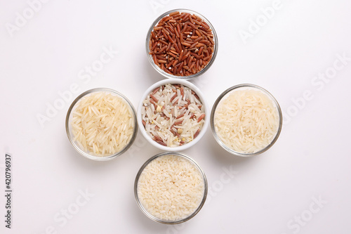 Long grain basmati medium grain jasmine short grain pilaf polau risotto brown low glycaemic index gi rice in small glass bowl on white background copy text space top flat lay view