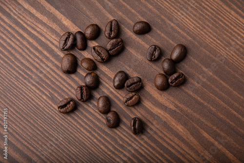 Roasted coffee beans on a wooden background.Top view