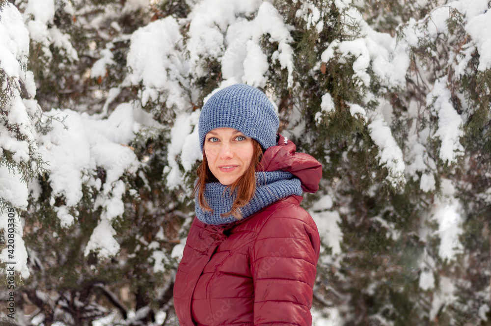 Winter portrait of a girl. Girl in warm clothes. Portrait of a woman in a winter park. Winter portrait of a girl. Girl in warm clothes. Portrait of a woman in a winter park.