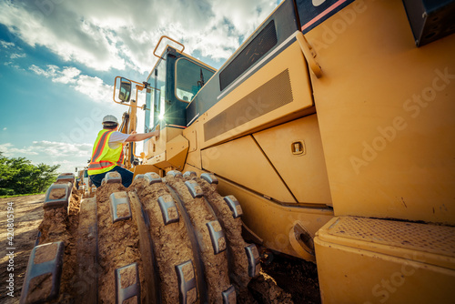 excavator and worker on a sunny day on construction site