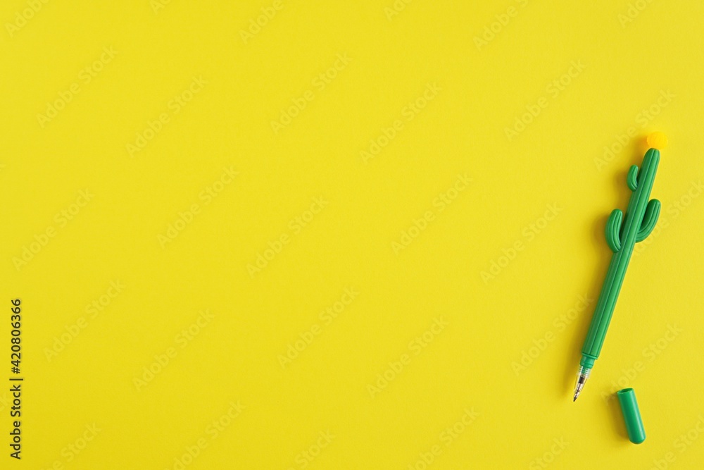 Minimal creative yellow desk with cactus shape gel pen, kids creativity, art, back to school background, space for text or product presentation. Minimal creative yellow desk with cactus shape gel pen, kids creativity, art, back to school background, space for text or product presentation.