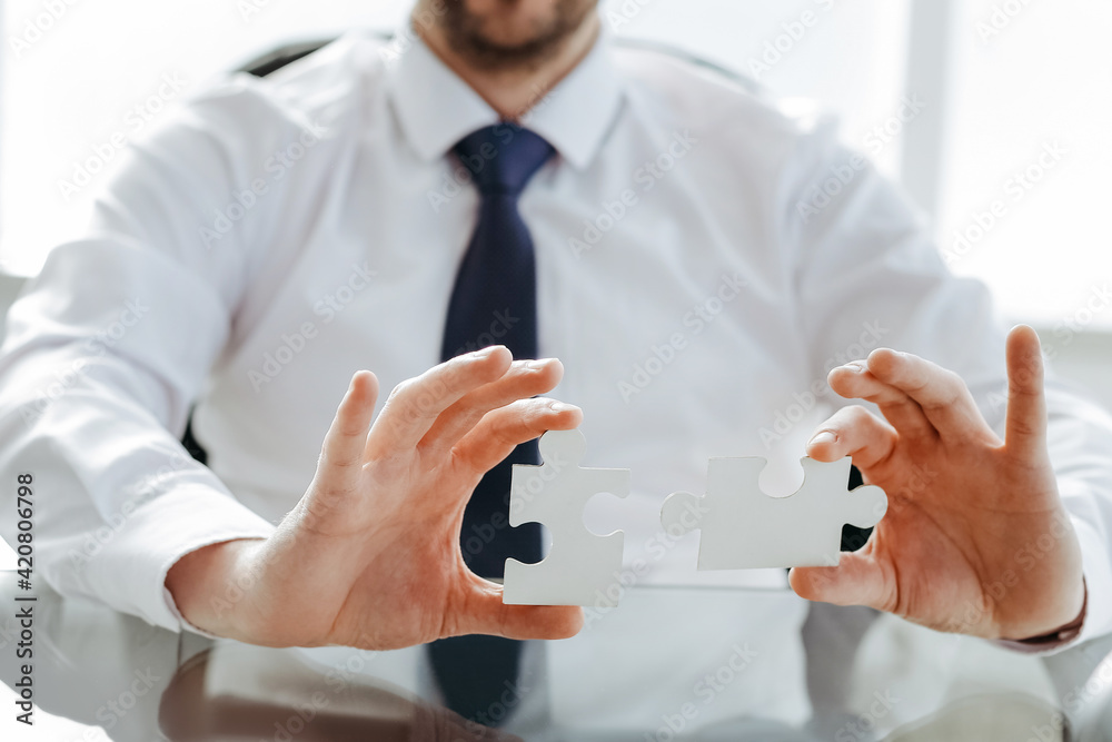 image of a happy businessman putting together the puzzle pieces. image of a happy businessman putting together the puzzle pieces.