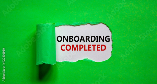 Onboarding completed symbol. Words 'Onboarding completed' appearing behind torn green paper. Beautiful green background. Business, onboarding completed concept, copy space.