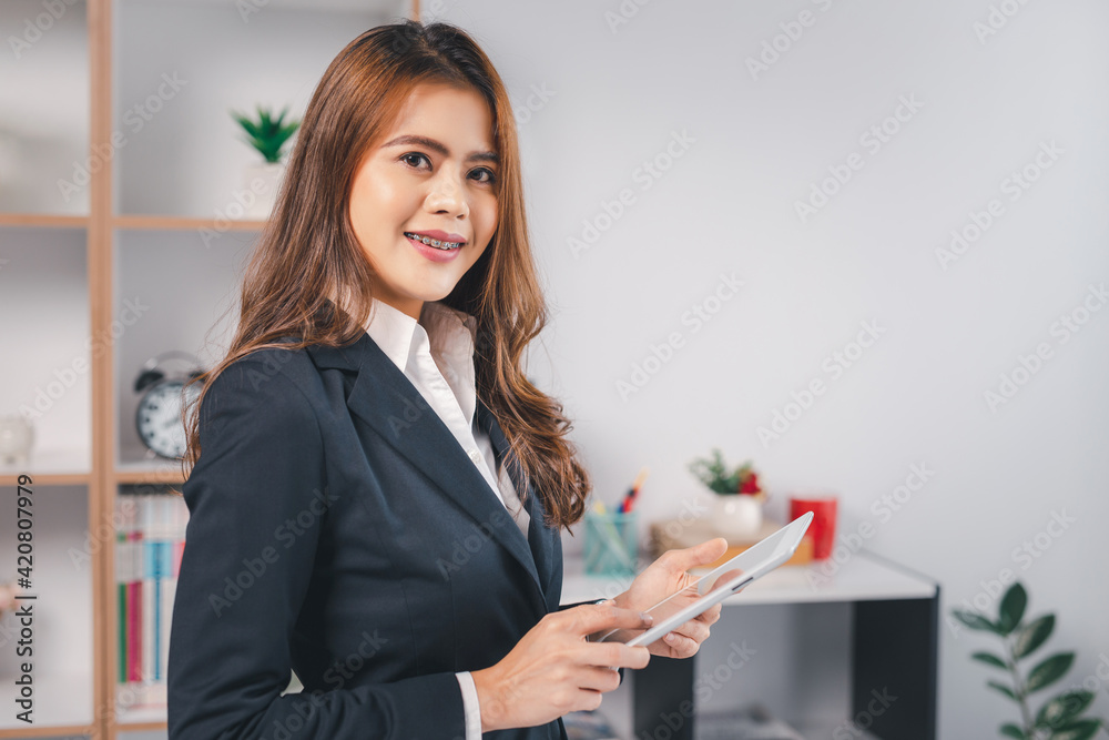 Portrait smiling young woman using tablet computer in the office. Portrait smiling young woman using tablet computer in the office.