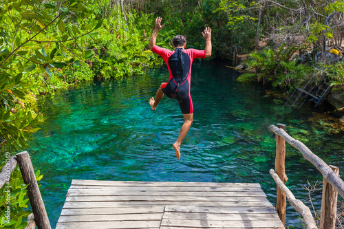 man jumping into a cenote in cancun photo