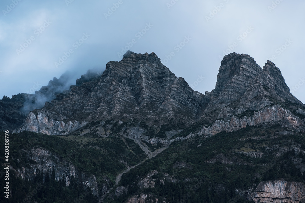 Rocky peaks under the afterglow of cloudy and overcast sky