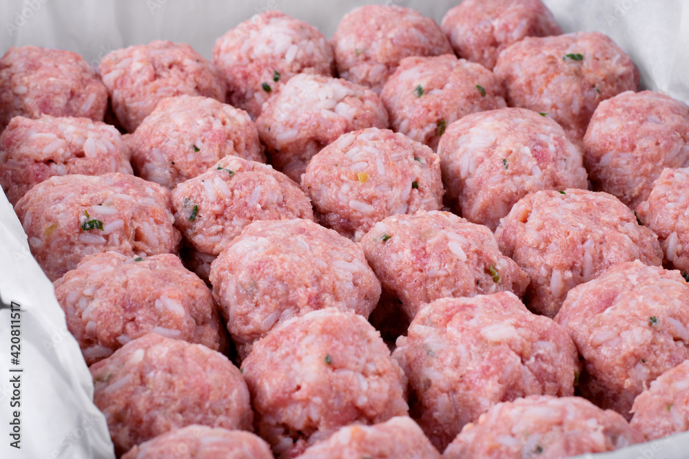 Raw meatballs with rice in the oven tray prepared to be roasted. Making a hot meal Raw meatballs with rice in the oven tray prepared to be roasted. Making a hot meal